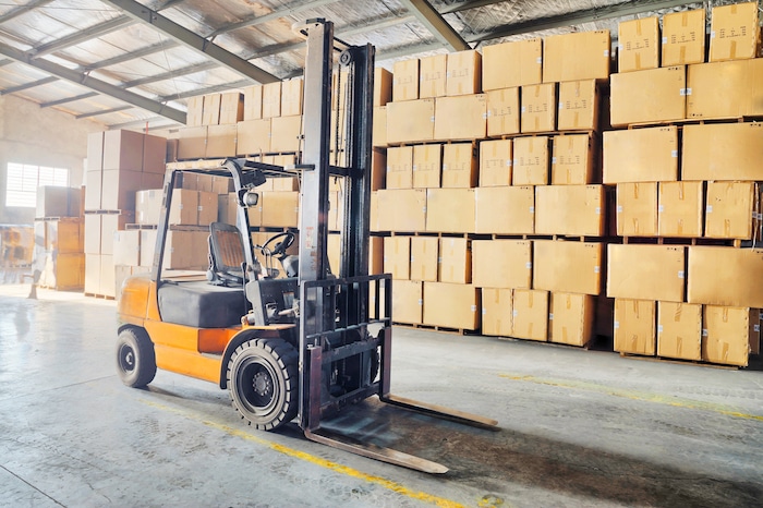 forklift in front of large stack of boxes