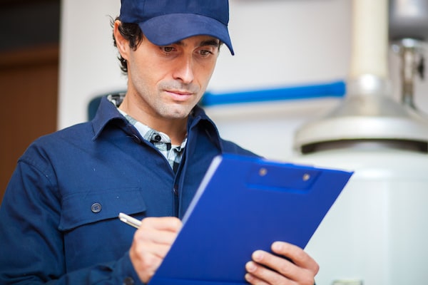 Man inspecting a scissor lift with a clipboard audit form