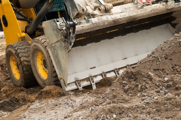 Skid steer loader with bucket of dirt