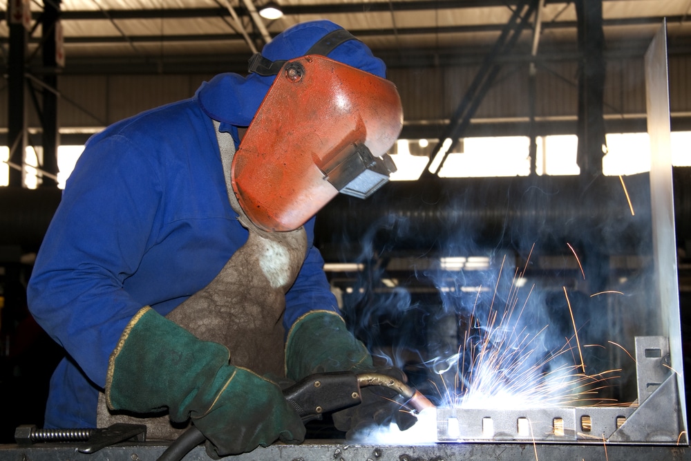 A welder working in a factory while wearing full ppe