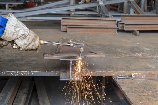 Metal Worker Cuts Material WIth Torch