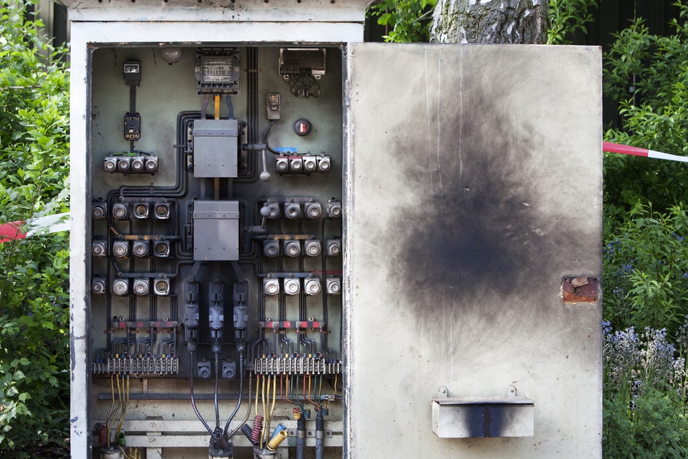 A metal box with wires on it which has sustained a fire or explosion