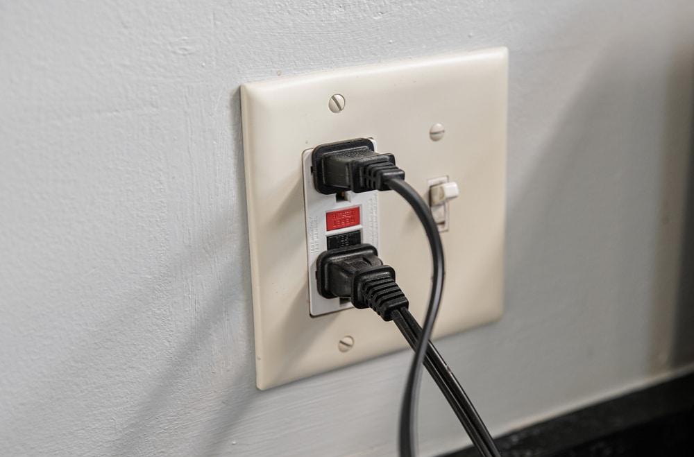 A wall outlet with two wires connected to it.