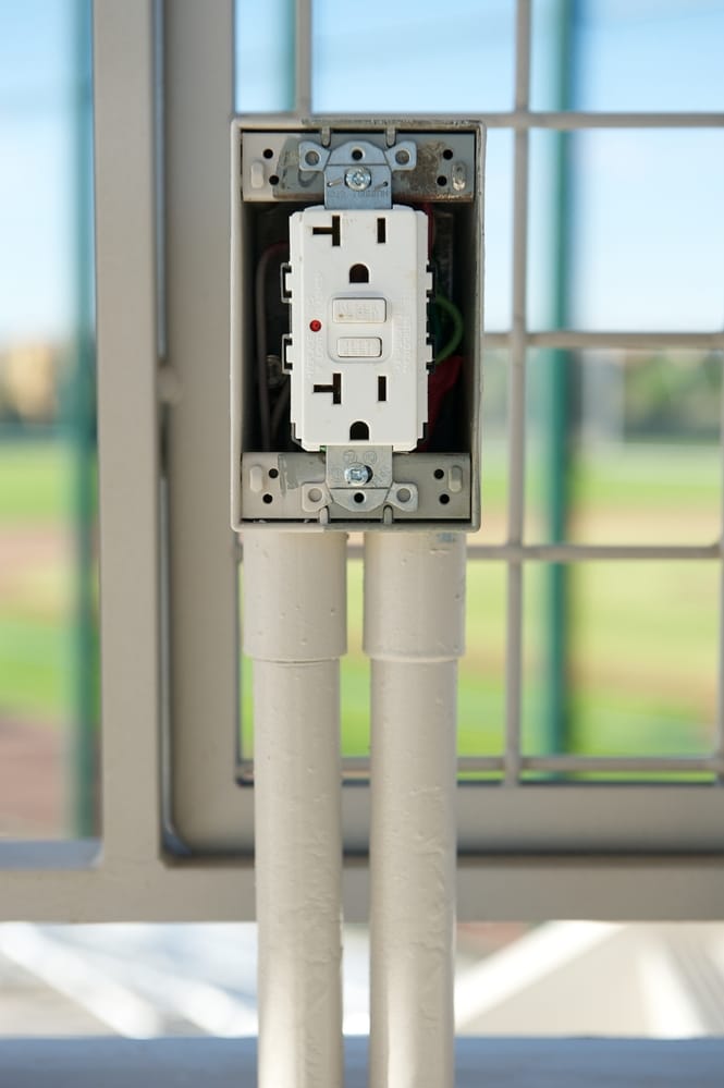 A white electrical box with a white GFCI outlet in it.