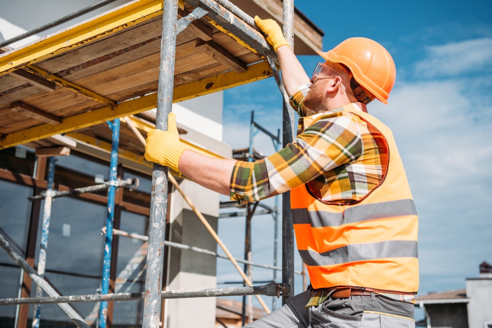 A construction worker is working on a scaffolding.