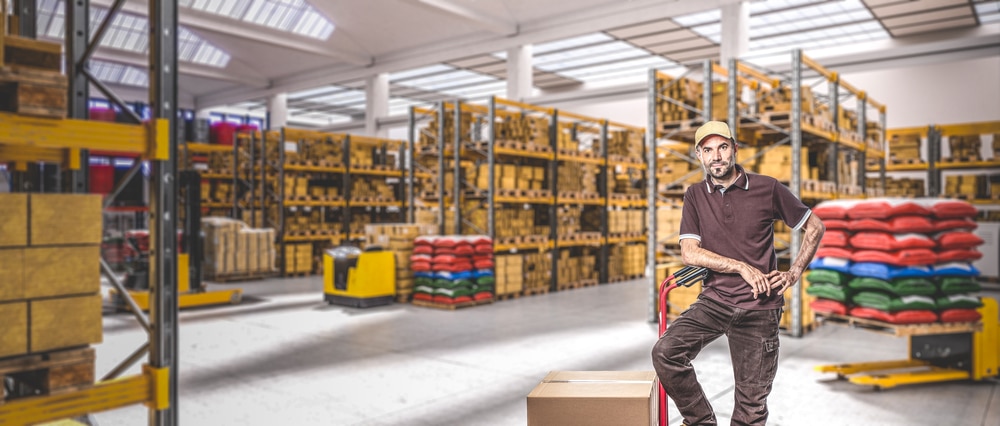 A man standing in a warehouse with boxes.