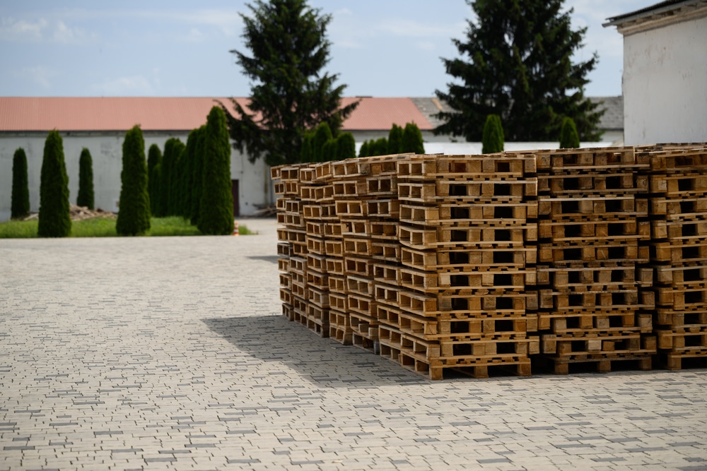 Wooden pallets stacked in front of a building.