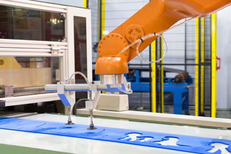 A robot is working on a blue piece of plastic.