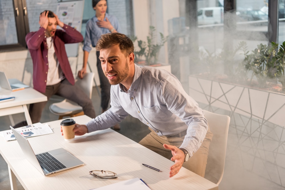 A group of people sitting at a table in an office who was just intruded by an active shooter