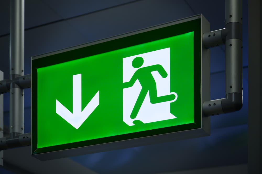 A green exit sign with an arrow pointing down.